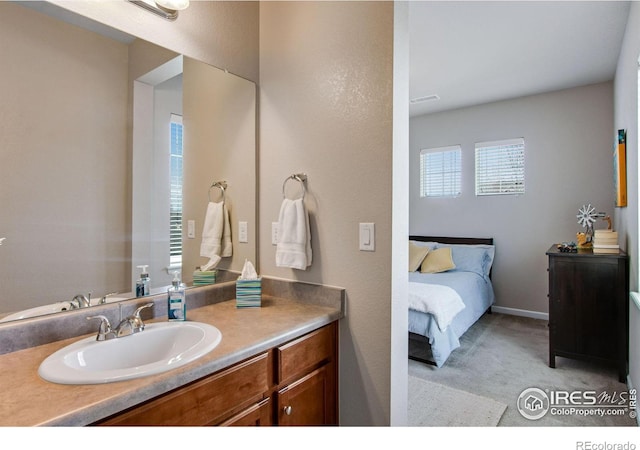 ensuite bathroom featuring ensuite bath, baseboards, and vanity