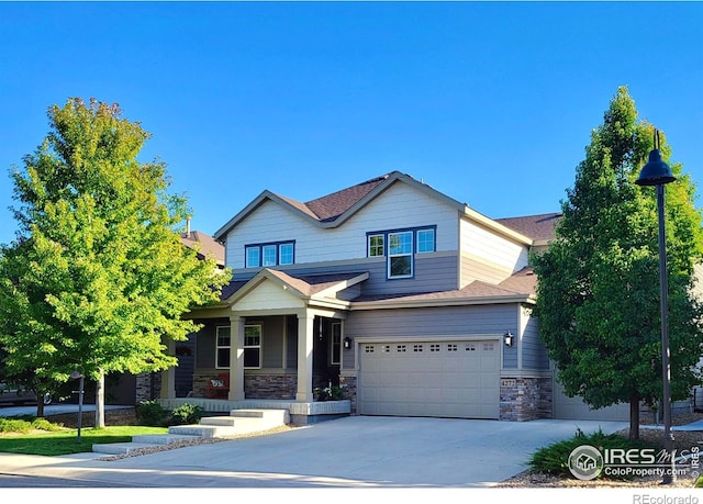 craftsman-style home featuring a garage, stone siding, and concrete driveway