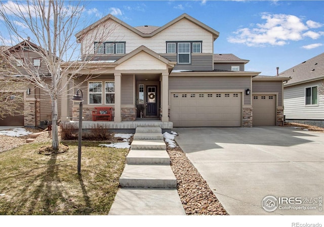 craftsman house featuring driveway, covered porch, and stone siding