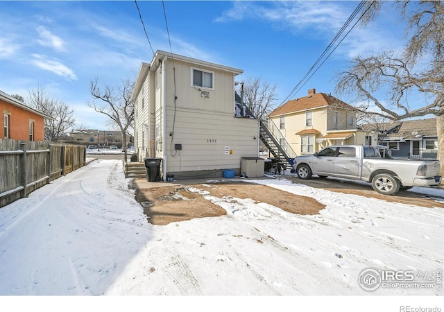 exterior space featuring central AC unit, stairs, a residential view, and fence