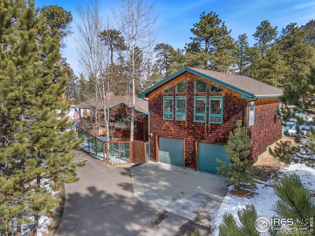 rustic home featuring driveway and an attached garage