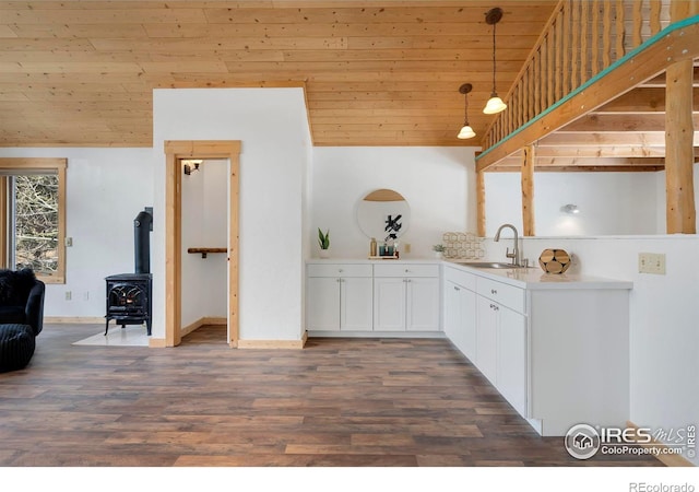 kitchen with white cabinets, wooden ceiling, hanging light fixtures, light countertops, and a sink