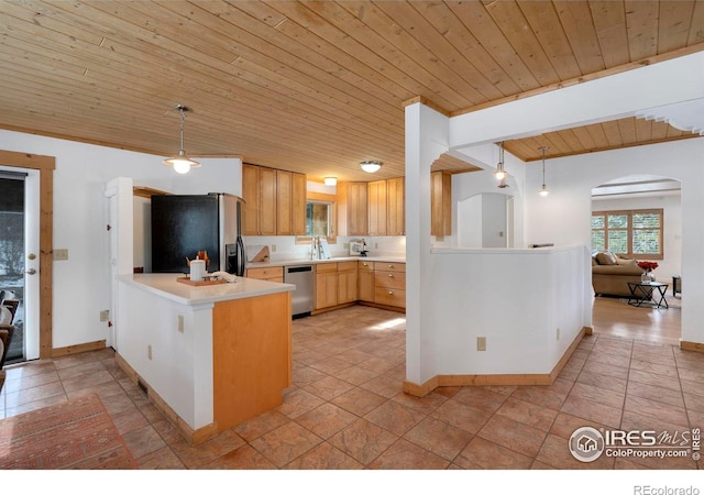 kitchen featuring light countertops, appliances with stainless steel finishes, a peninsula, and decorative light fixtures