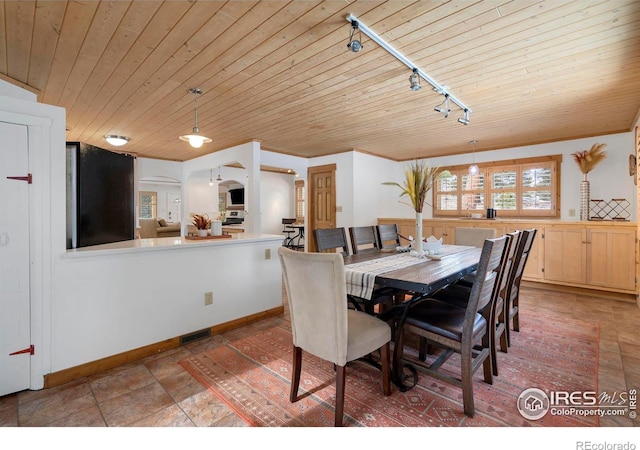 dining room with visible vents, baseboards, arched walkways, wooden ceiling, and crown molding