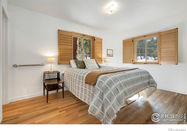 bedroom with wood finished floors and baseboards