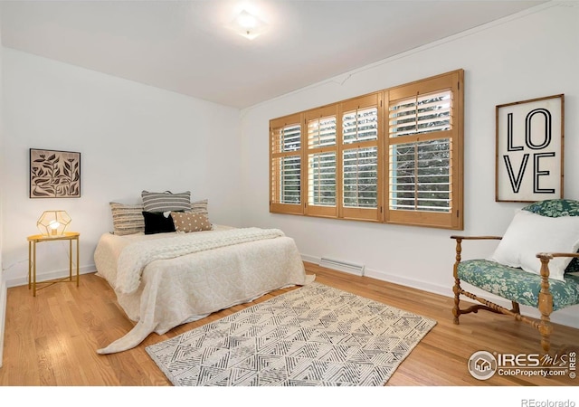 bedroom featuring wood finished floors, visible vents, and baseboards