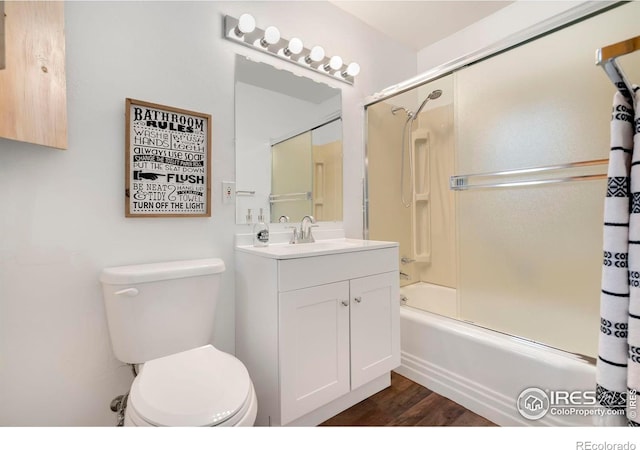 bathroom with bath / shower combo with glass door, wood finished floors, vanity, and toilet