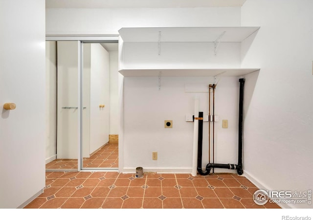 clothes washing area featuring laundry area, hookup for an electric dryer, and baseboards