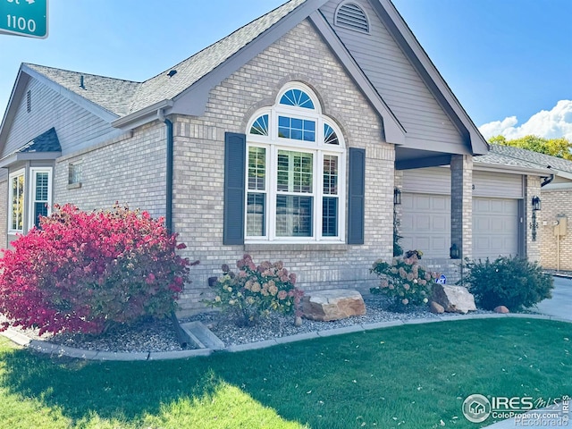 view of property exterior with brick siding, a lawn, and an attached garage