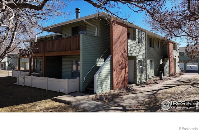 exterior space with a balcony, fence, and stairway