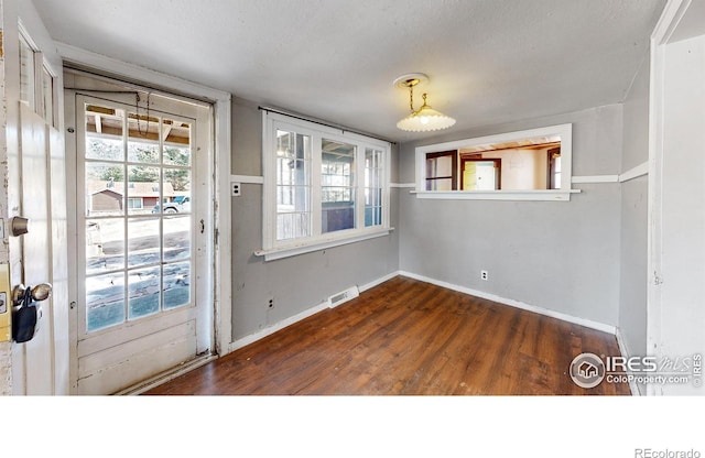 entryway with dark wood-style flooring, visible vents, and baseboards