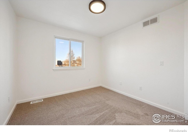 carpeted empty room with visible vents and baseboards