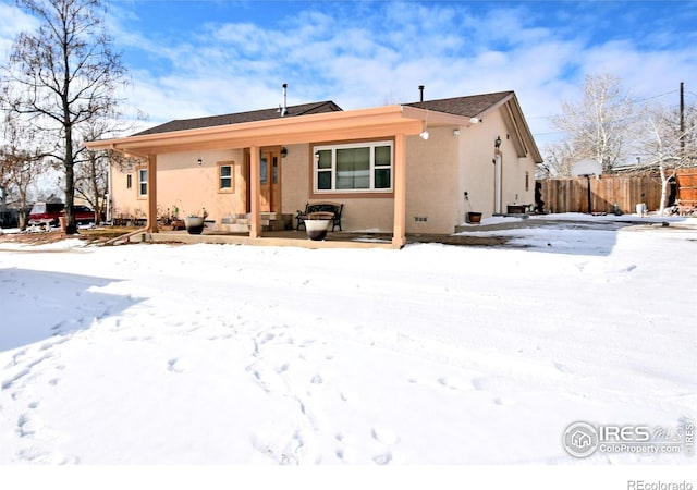 view of front of house with fence and stucco siding