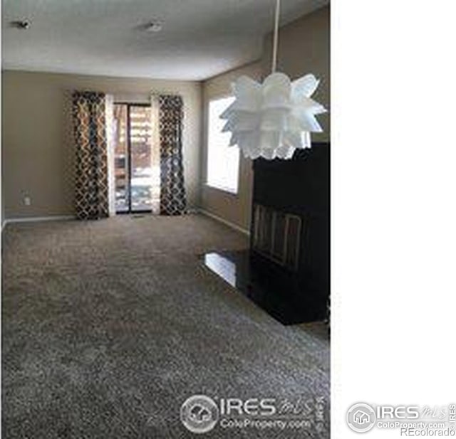 carpeted living room with a fireplace with flush hearth