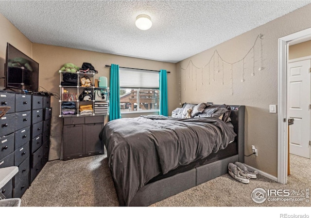 bedroom featuring carpet and a textured ceiling