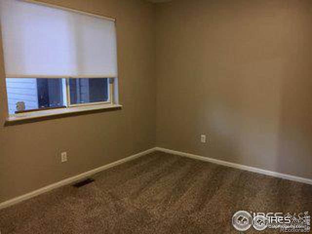 carpeted spare room with visible vents and baseboards