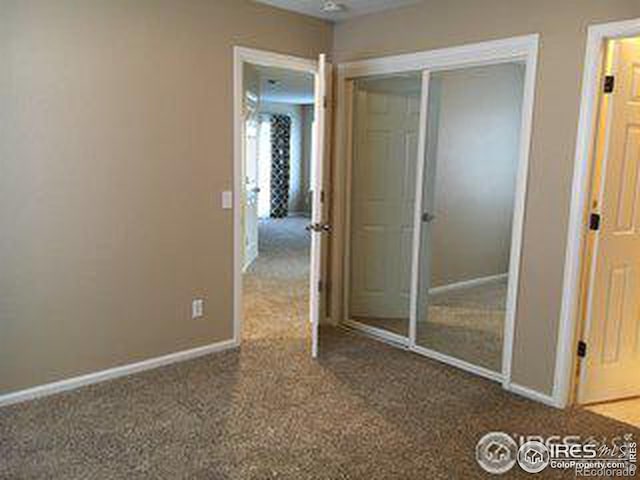 unfurnished bedroom with a closet, carpet, and baseboards