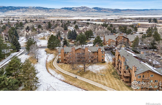 snowy aerial view with a residential view and a mountain view