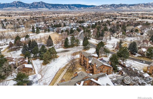 snowy aerial view with a residential view and a mountain view