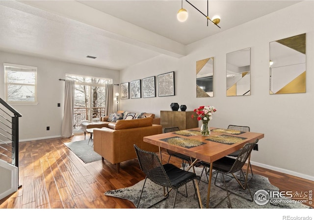 dining area featuring stairs, baseboards, and wood finished floors