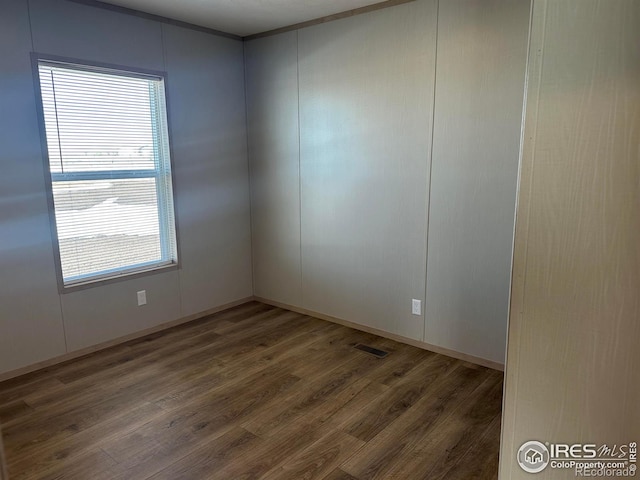 spare room featuring visible vents and wood finished floors