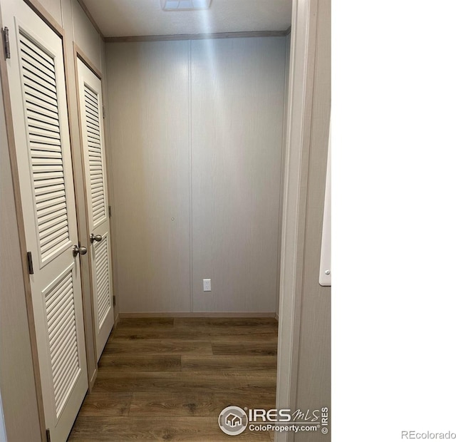 interior space featuring a closet, ornamental molding, and wood finished floors