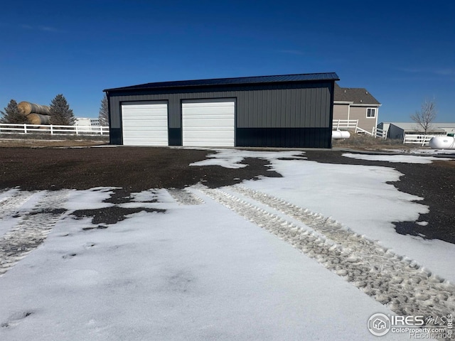 exterior space with a detached garage and fence