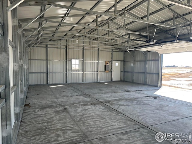 garage with a garage door opener, electric panel, and metal wall