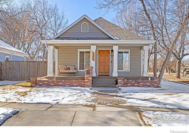 view of front of property featuring a porch, roof with shingles, and fence