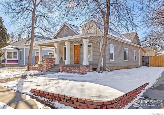 view of front of property featuring a porch and fence