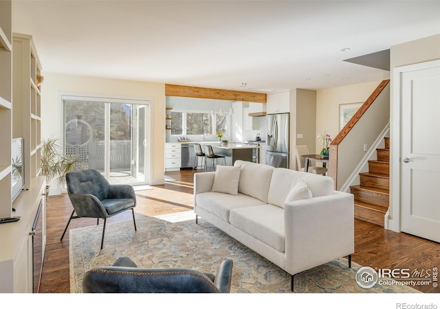 living area featuring stairway and wood finished floors