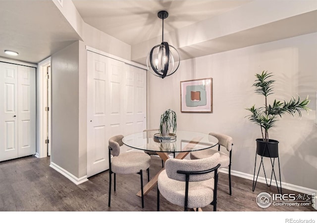 dining space with dark wood-style floors, an inviting chandelier, and baseboards