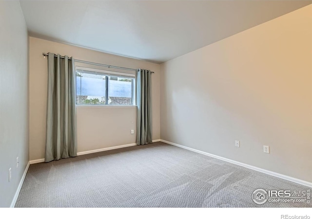 spare room with carpet and baseboards