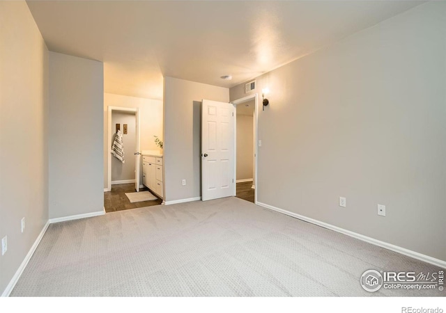 unfurnished bedroom with carpet floors, visible vents, connected bathroom, and baseboards