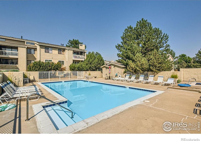 pool with fence and a patio