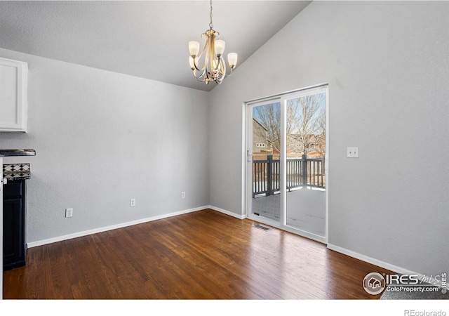 unfurnished dining area with a notable chandelier, visible vents, baseboards, vaulted ceiling, and dark wood finished floors