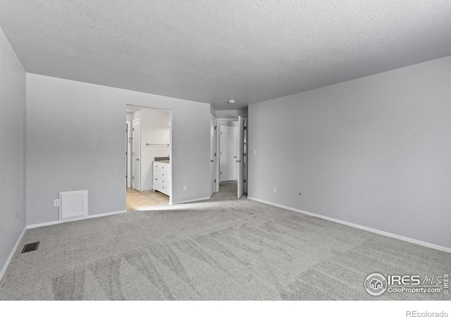 unfurnished bedroom with light carpet, connected bathroom, visible vents, and baseboards