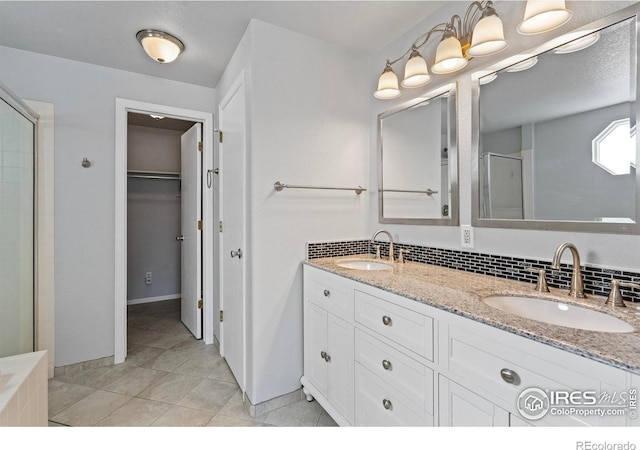 full bathroom with double vanity, decorative backsplash, a sink, and a shower stall