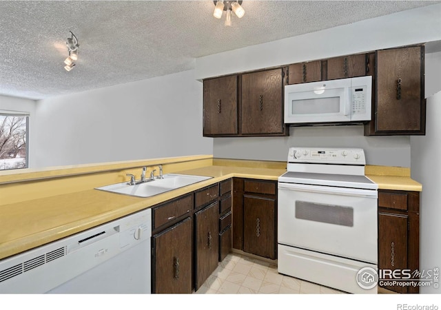 kitchen featuring white appliances, marble finish floor, light countertops, a textured ceiling, and a sink