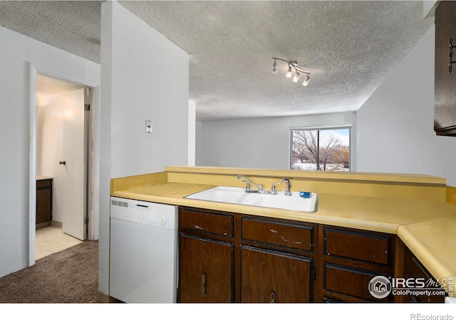 kitchen featuring light countertops, dark brown cabinetry, a textured ceiling, a sink, and dishwasher