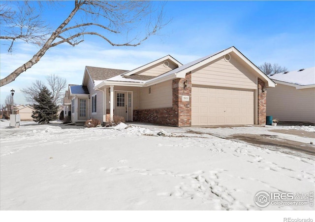 single story home featuring an attached garage and brick siding