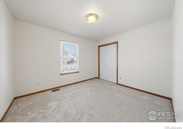 unfurnished room with light carpet, baseboards, and visible vents