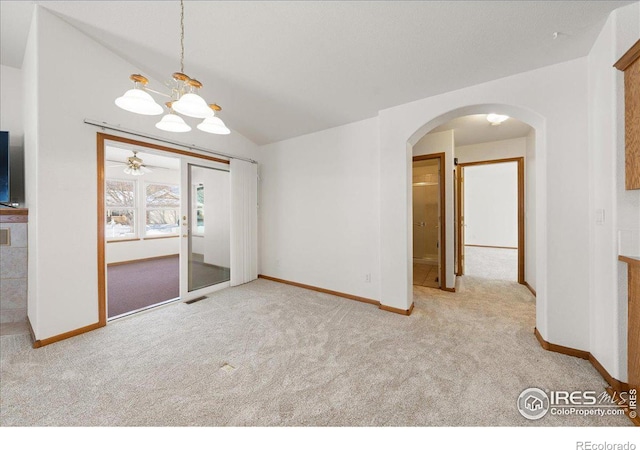 empty room with light carpet, visible vents, arched walkways, baseboards, and lofted ceiling