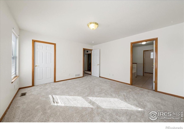 unfurnished bedroom featuring light carpet, baseboards, and visible vents