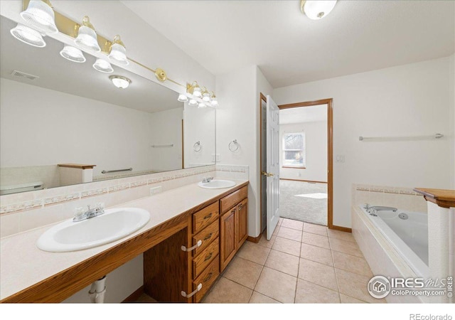 bathroom with a garden tub, tile patterned flooring, baseboards, and a sink