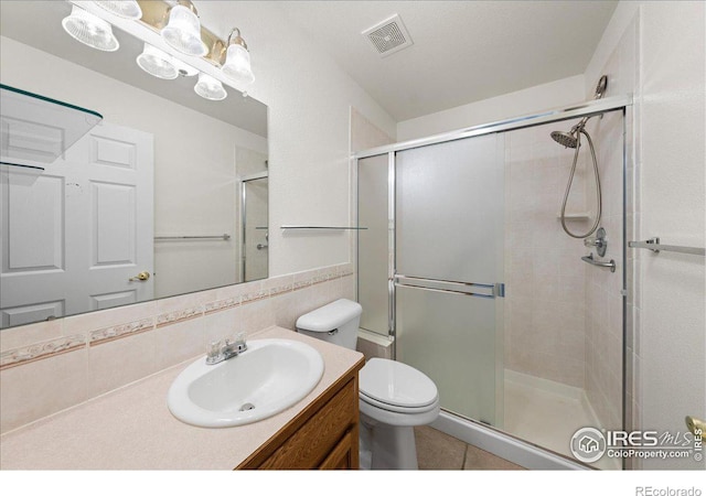 bathroom with a stall shower, visible vents, backsplash, and toilet