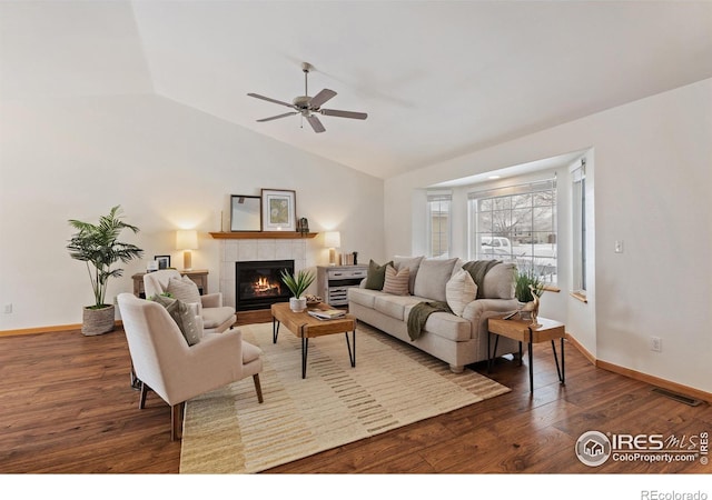 living area featuring lofted ceiling, dark wood-style flooring, a fireplace, and baseboards