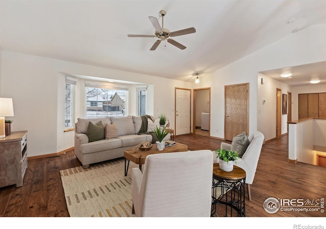 living area featuring dark wood-style floors, baseboards, vaulted ceiling, and a ceiling fan