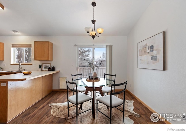 dining space with dark wood-style floors, baseboards, a chandelier, and vaulted ceiling