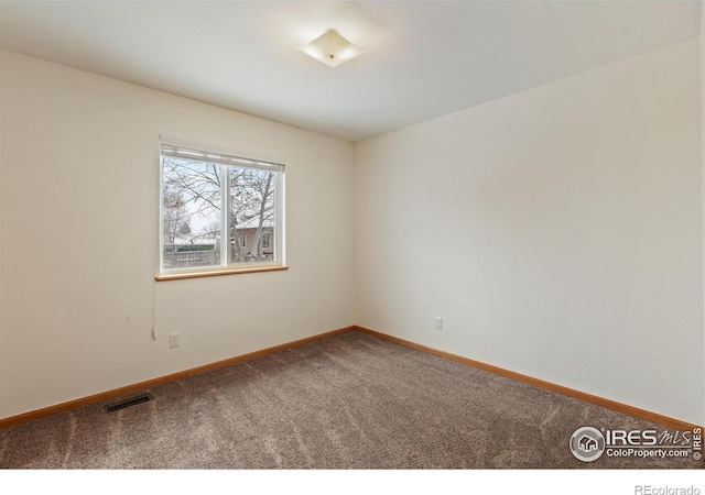 unfurnished room with carpet, visible vents, and baseboards